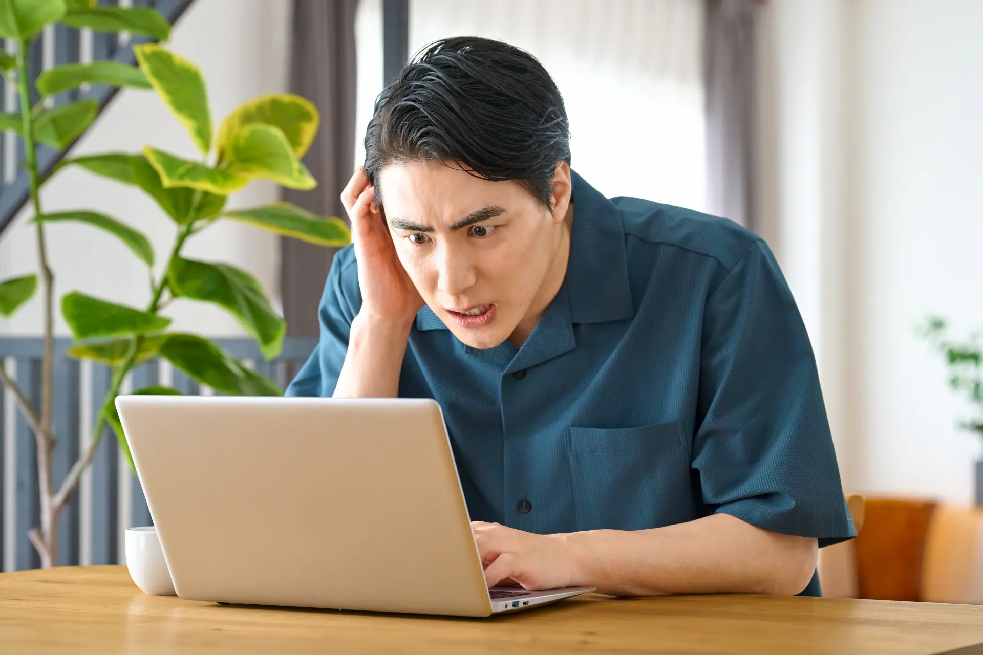 PCの前で頭を抱える男性　投資　ウィルス